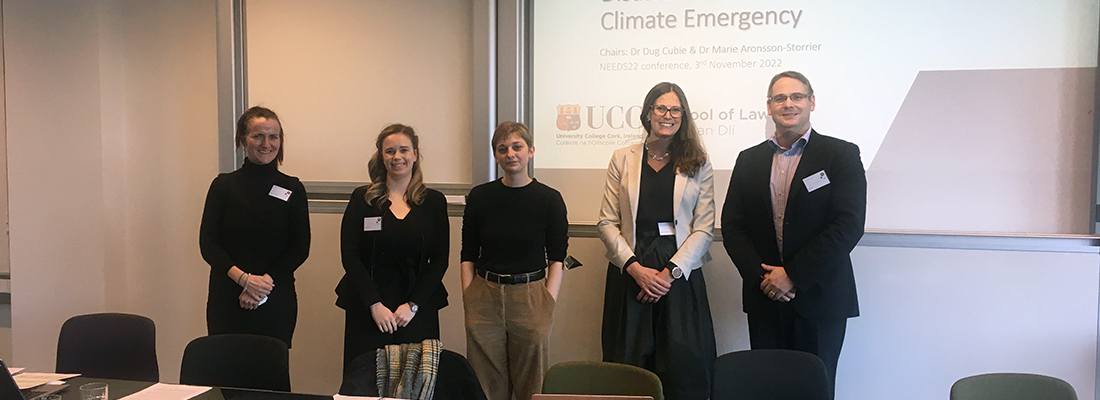 five people standing in front of a powerpoint projection with the words Climate Emergency visible